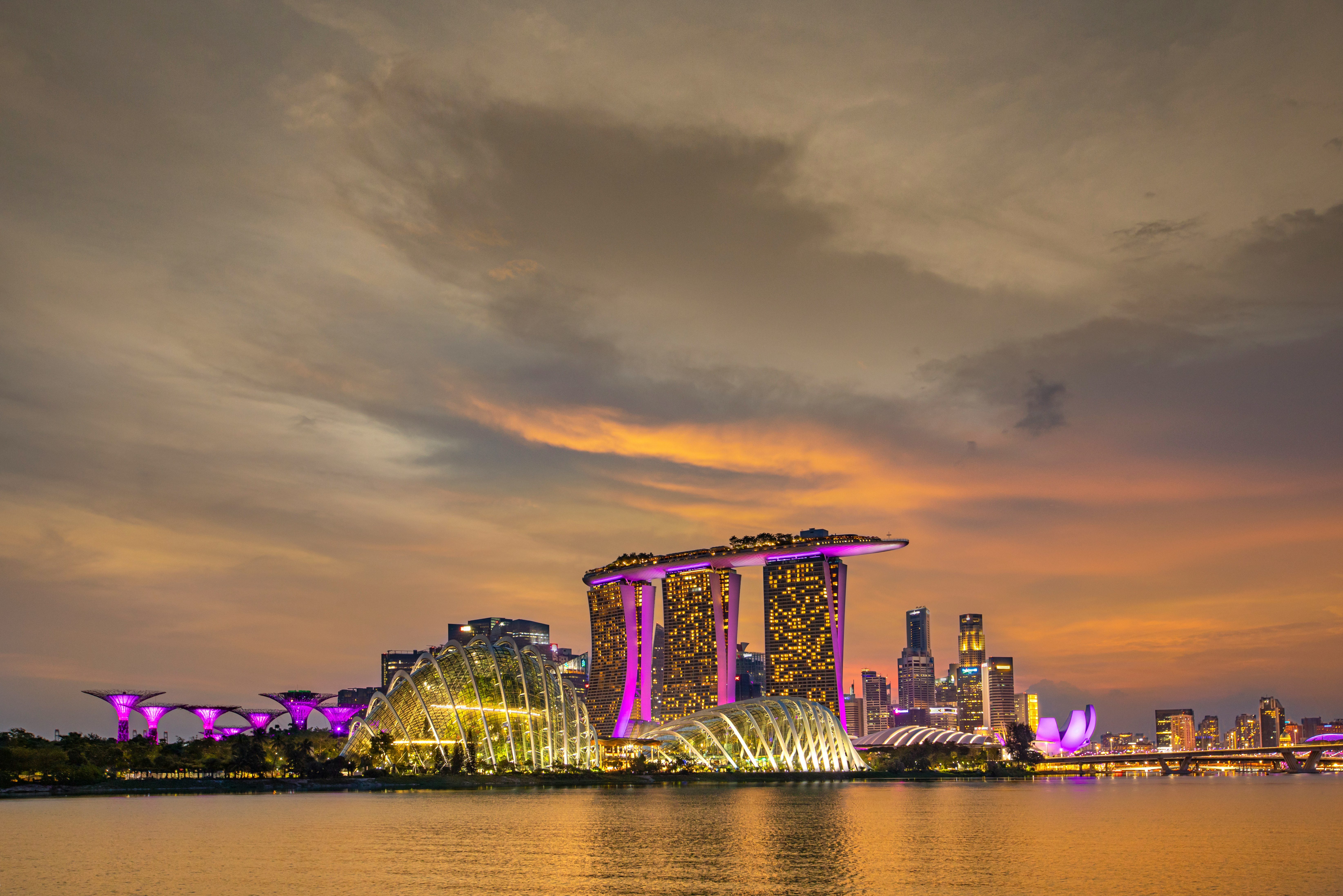 city skyline across body of water during night time